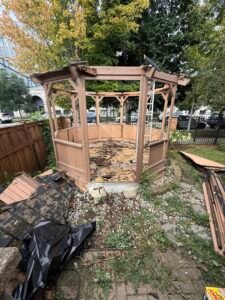 Wooden backyard gazebo partially dismantled during demolition in Chicago, IL
