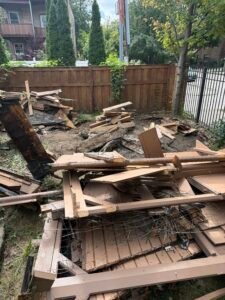 Pile of dismantled wooden gazebo materials and demolition debris in a Chicago backyard